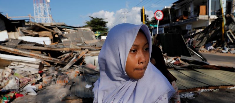 Menschen laufen in der Nähe der Ruine eines Geschäfts nachdem Erdbeben die Insel Lombok erschüttert haben. Menschen laufen in der Nähe der Ruine eines Geschäfts nachdem Erdbeben die Insel Lombok erschüttert haben.