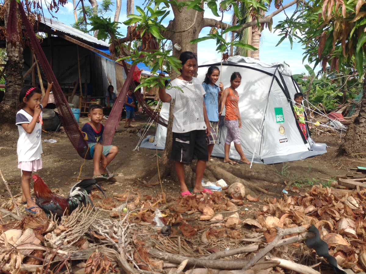Eine Familie, die nach dem Taifun Haiyan ein Zelt von ShelterBox erhalten hat.