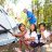 Drei Mädchen sitzen in einer Hängematte vor ihrem neuen ShelterBox Zelt