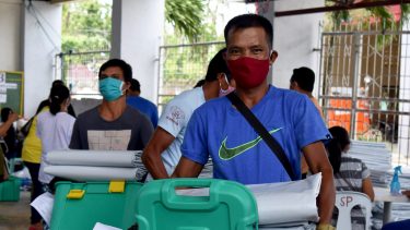 Mann trägt shelterboxkiste