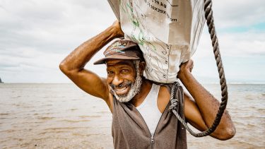 Mann auf Vanuatu trägt Shelter Kit nach Zyklon Harold