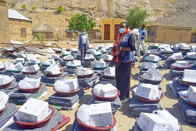 Eine Helferin steht zwischen den Hilfsgütern nach der Überschwemmung im Sudan