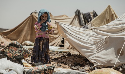Ein Kind in schmutziger Kleidung steht zwischen Zelten im Jemen